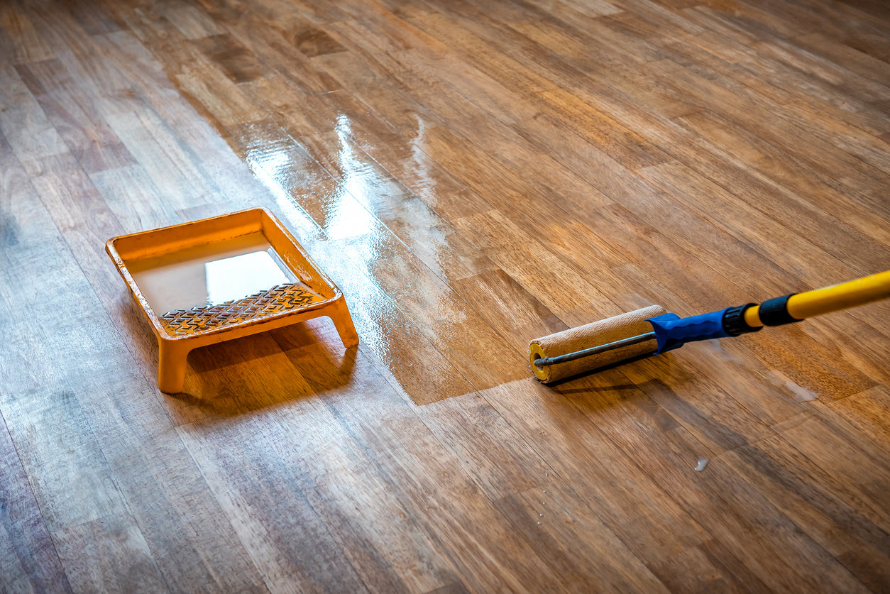 hardwood floor installer applying finisher to wood floors